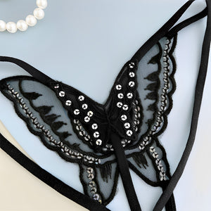 Calcinha preta com desenho de borboleta em renda e detalhes brilhantes, detalhe da renda